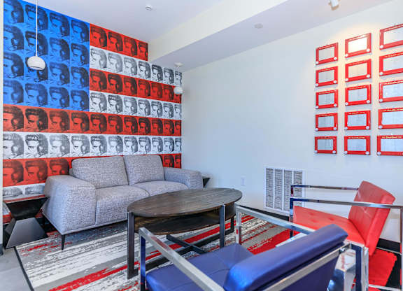 A living room with a grey couch, a red chair, and a table.