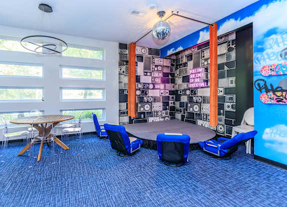 A room with a blue carpet and a wooden table with chairs.