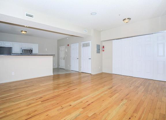 A large empty room with wooden floors and white walls.