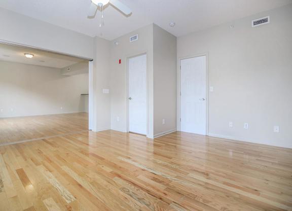A room with wooden flooring and white walls.