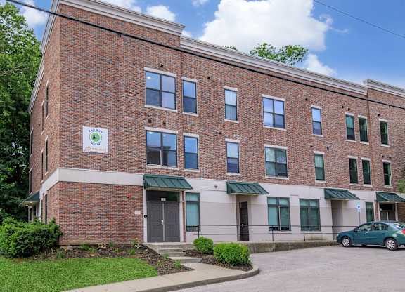 A brick building with a green awning and a sign on the front.