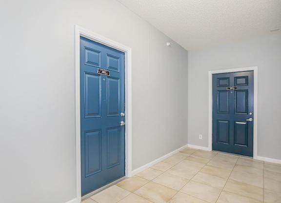 A room with a blue door and a white wall.
