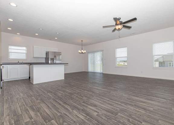 A spacious room with a ceiling fan and wooden flooring.