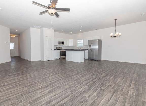 A spacious room with a ceiling fan and wooden flooring.