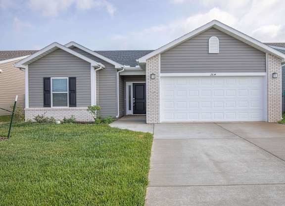 A house with a grey roof and a white garage door.