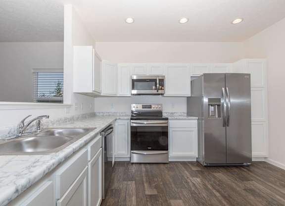 A modern kitchen with stainless steel appliances and white cabinets.