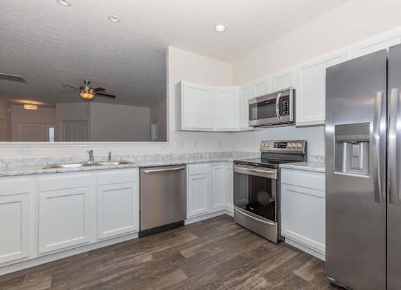 A kitchen with white cabinets and stainless steel appliances.