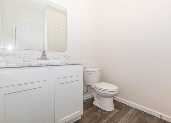 A white toilet sits next to a sink in a bathroom.