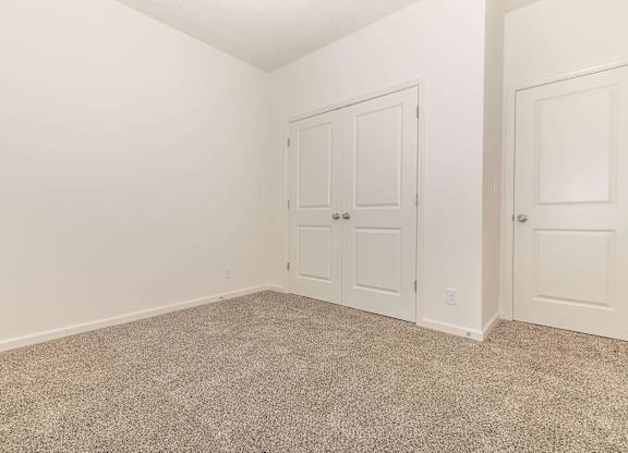 A room with a carpeted floor and white walls.
