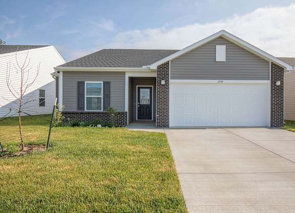 A house with a grey roof and a white garage door.