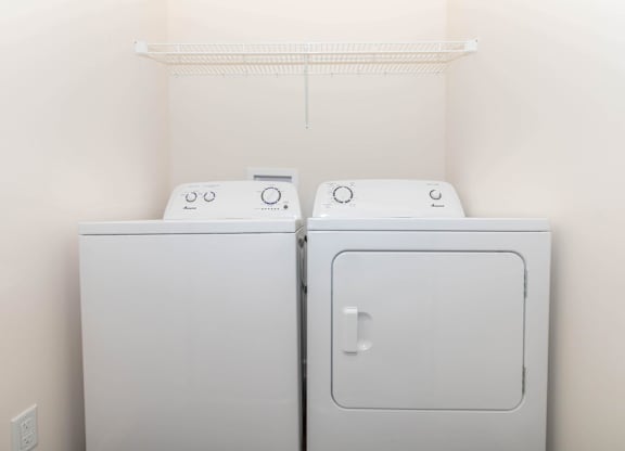 Two white washing machines in a laundry room.