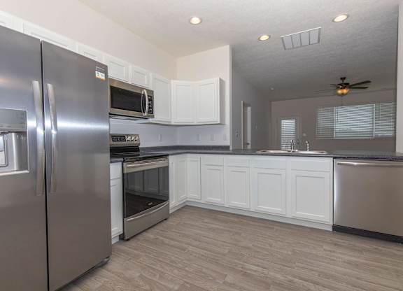 A modern kitchen with stainless steel appliances and white cabinets.