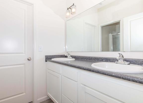 A bathroom with a white door and a white sink.
