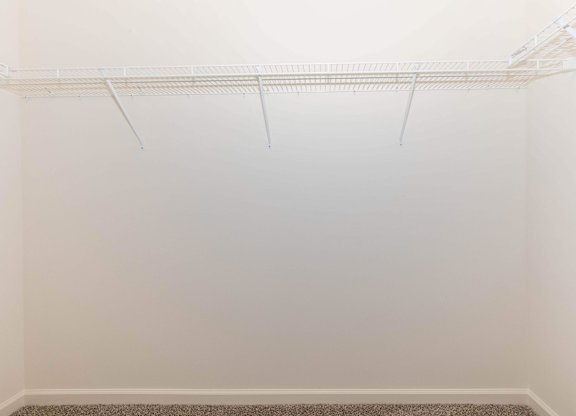 Empty white room with a shelf on the wall.