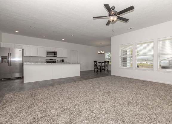 A spacious kitchen with a fan on the ceiling.