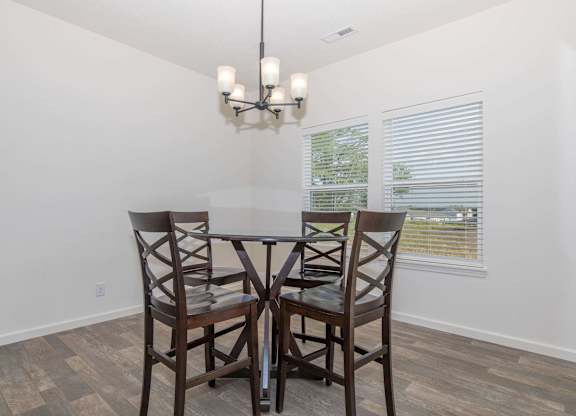 A dining room with a table and chairs.
