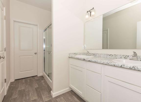 A bathroom with a marble countertop and a large mirror.