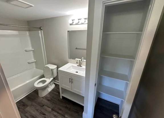 A bathroom with a toilet, sink, and shower.