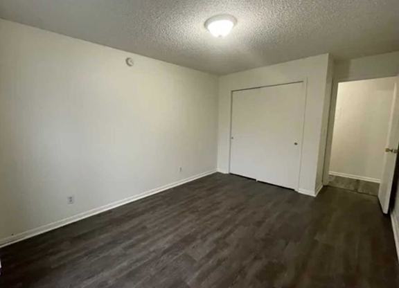 A room with a white door and a grey floor.