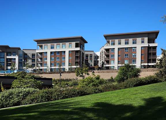 A row of modern buildings with balconies and large windows.