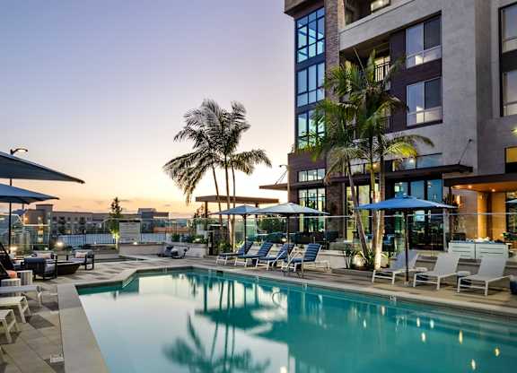 A modern building with a pool in front of it.