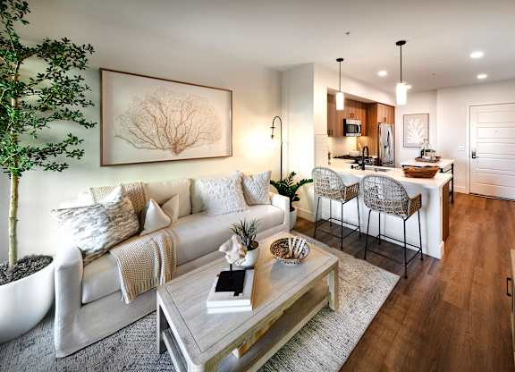 A modern living room with a white sofa and a glass coffee table.