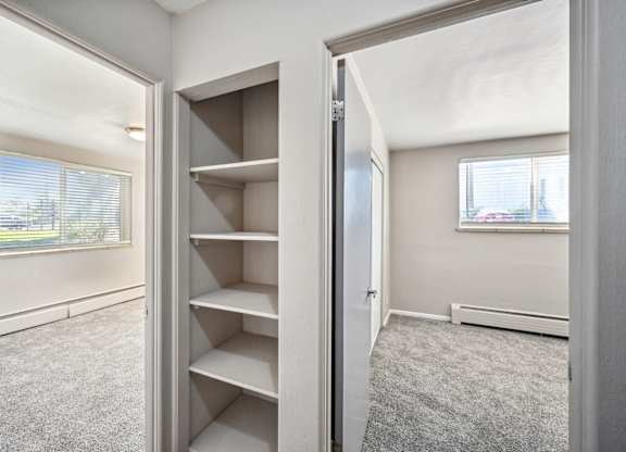 an empty closet with shelves in a room with a window at Park at Fitzsimons Apartments, Aurora, Colorado