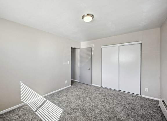 A room with a carpeted floor and a white ceiling with a light fixture. at Park at Fitzsimons Apartments, Aurora, Colorado