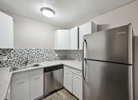 the kitchen has stainless steel appliances and white cabinets at Park at Fitzsimons Apartments, Aurora, MO, 80011