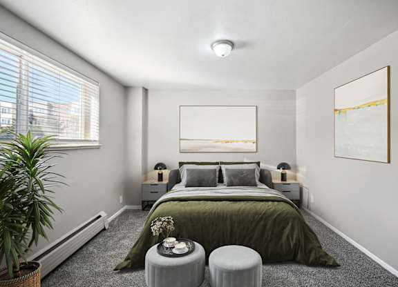 A bedroom with a large bed and a painting on the wall. at Park at Fitzsimons Apartments, Aurora, MO
