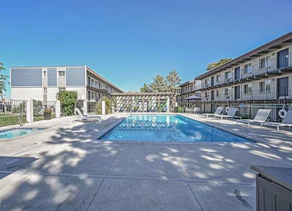 our apartments have a large pool and a patio with chairs at Park at Fitzsimons Apartments, Aurora
