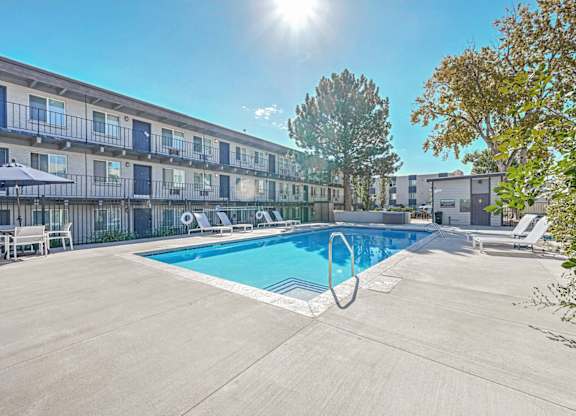 our apartments have a swimming pool and a patio with chairs at Park at Fitzsimons Apartments, Aurora 80011