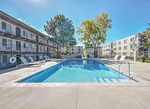 our apartments have a swimming pool and a patio with chairs at Park at Fitzsimons Apartments, Colorado, 80011