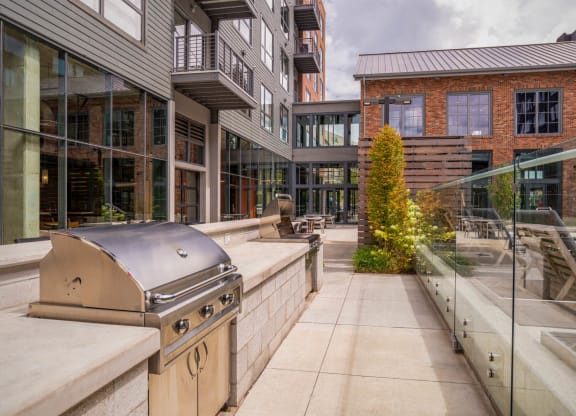 an outdoor patio with a grill and a building at The Audubon New Haven, New Haven, CT, 06511