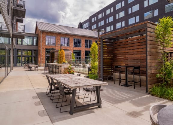 a patio with a table and chairs outside of a building at The Audubon New Haven, New Haven, CT, 06511