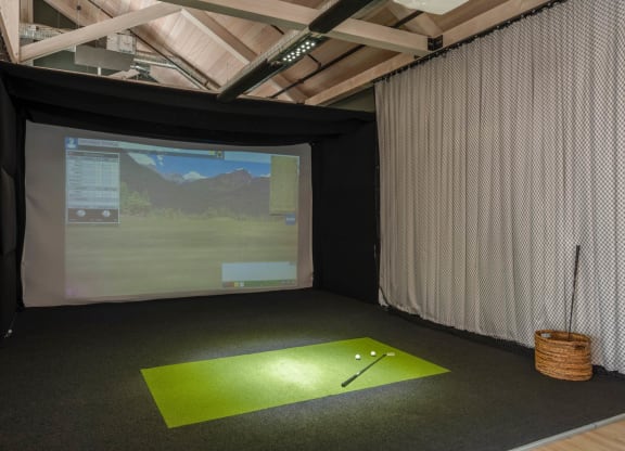 a golf simulator in a room with a screen and a golf ball at The Audubon New Haven, New Haven, 06511