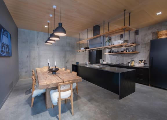 a kitchen with a wooden table and black cabinets at The Audubon New Haven, New Haven