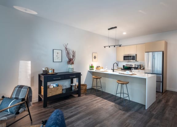 a kitchen and living room with an island and a refrigerator at The Audubon New Haven, New Haven, Connecticut