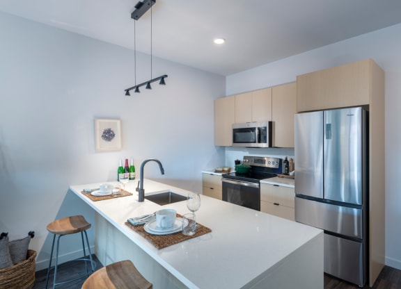 a kitchen with a large island and stainless steel refrigerator at The Audubon New Haven, Connecticut, 06511