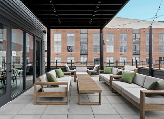 a communal patio with couches and tables on a rooftop at The Audubon New Haven, New Haven, CT, 06511