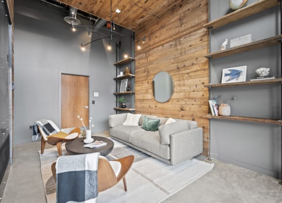 a living room with a gray couch and a wooden wall at The Audubon New Haven, New Haven, Connecticut