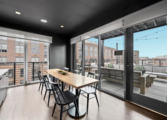 a dining area with a wooden table and chairs and a large window with a balcony at The Audubon New Haven, New Haven, Connecticut