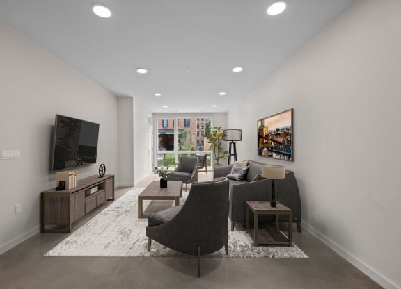 a living room with a gray couch and a tv at The Audubon New Haven, New Haven, 06511