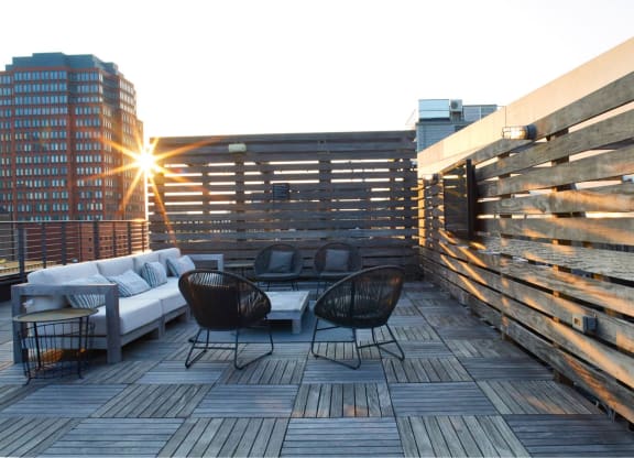 a roof deck with furniture and a building in the background at The Audubon New Haven, Connecticut, 06511