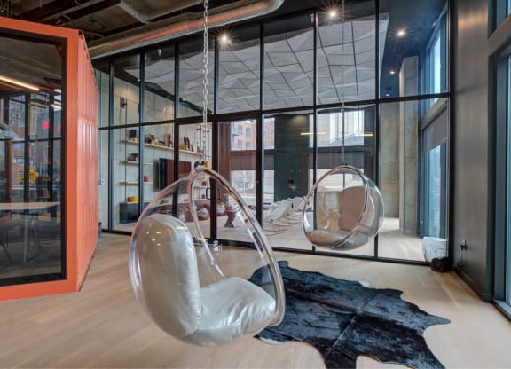 a pair of white chairs in a room with glass walls at The Audubon New Haven, New Haven
