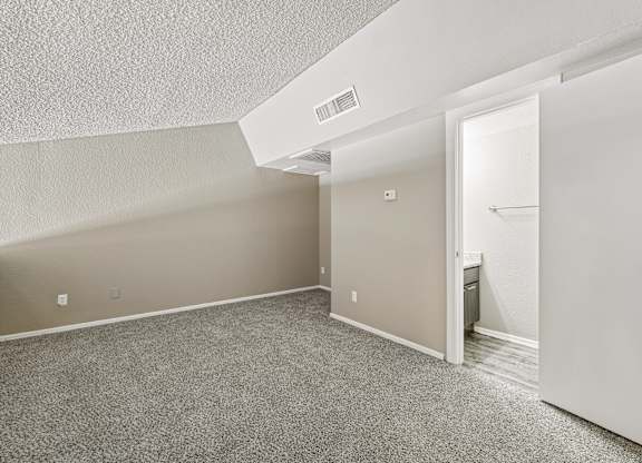 A room with a carpeted floor and a white door.