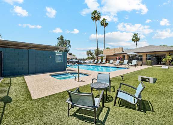 A pool with a table and chairs in the foreground.