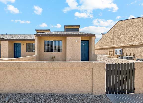 A house with a blue door and a wooden fence.