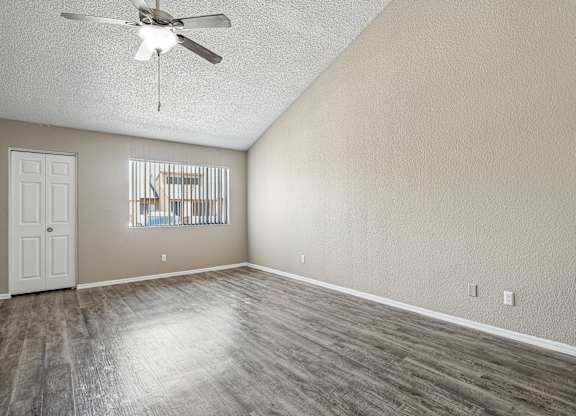 A room with a ceiling fan and wooden flooring.