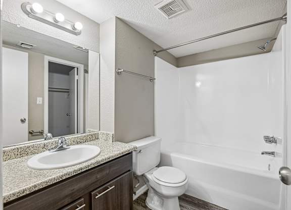 A white toilet sits next to a sink in a bathroom.
